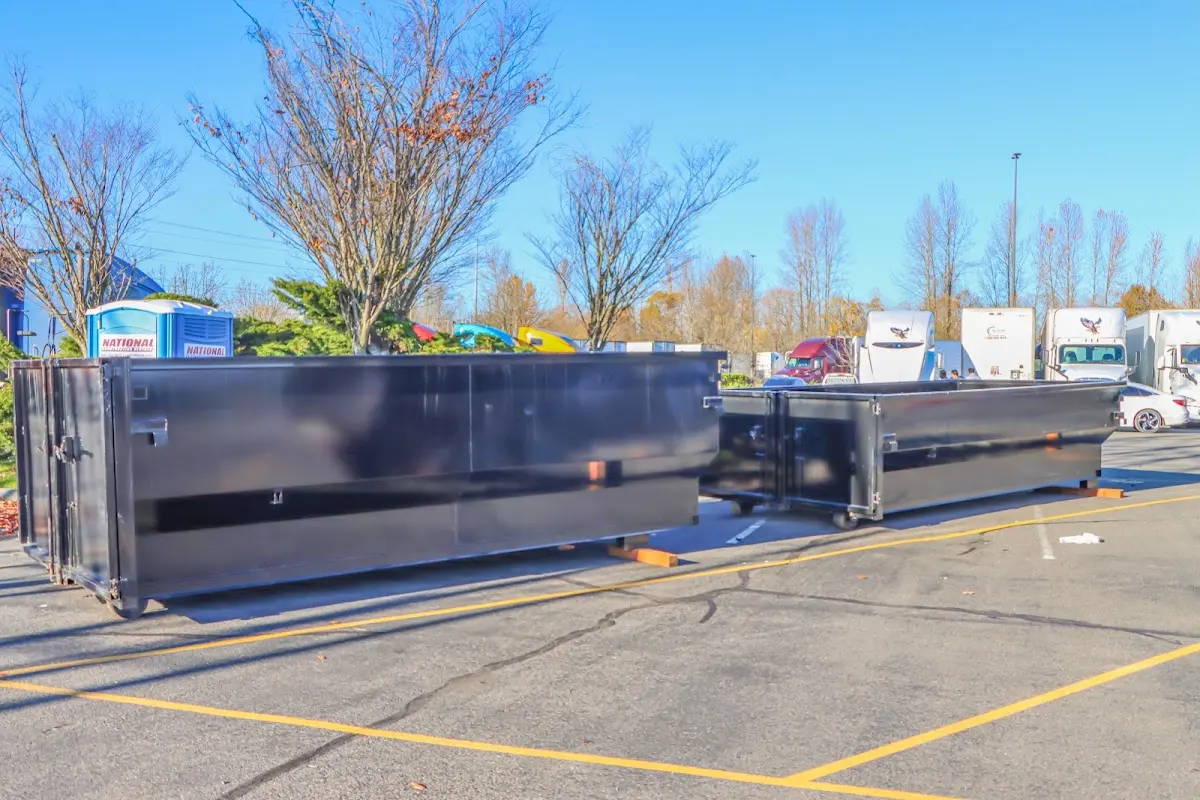 Professional dumpster rental service with roll-off container on residential driveway in Gunnison